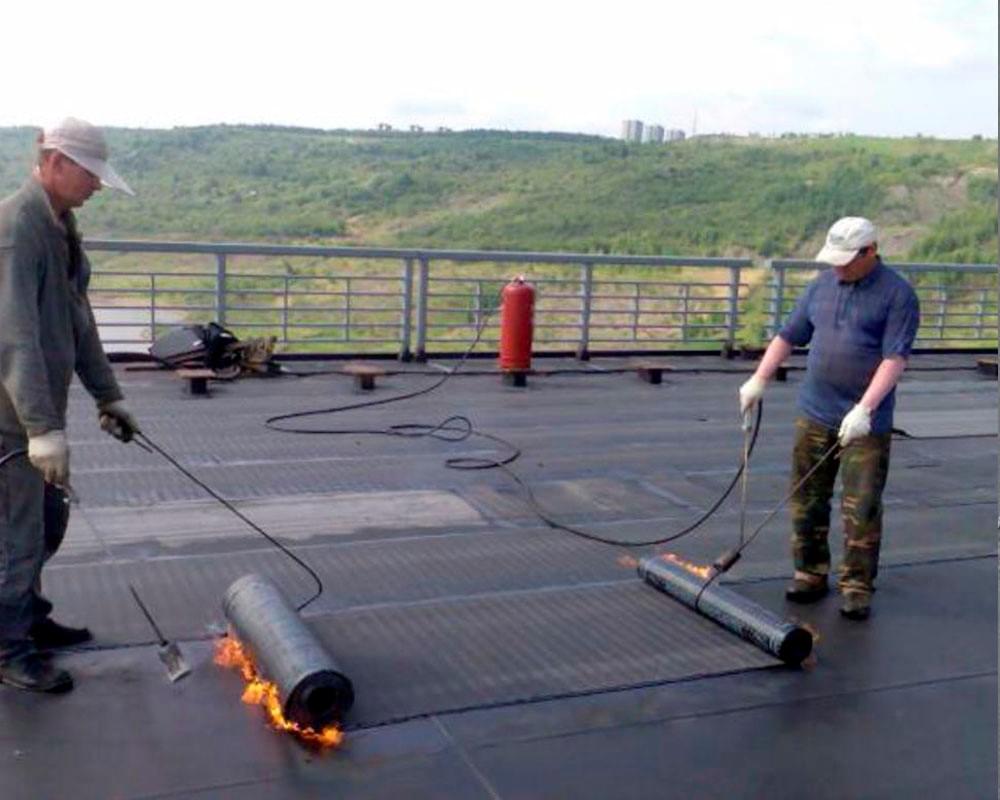 Укладка рулона на плоской крыше с применением газовой горелки